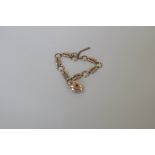 A 9ct gold bracelet having attached gem set heart shaped locket, 8.6g total weight.