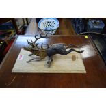An unusual cold painted bronze stag desk clip, the animal 24cm long, on oak plinth.