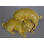 A Chinese yellow glazed figure group of two puppies, late 19th/early 20th century, 17cm wide.