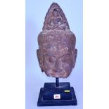 An antique Khmer style carved stone head, 35.5cm high, on stand.