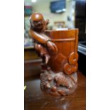 A Chinese carved wood figural brush pot, 18cm high.