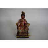 A Chinese polychrome painted, carved and lacquered figure of a seated lady, 23cm high.