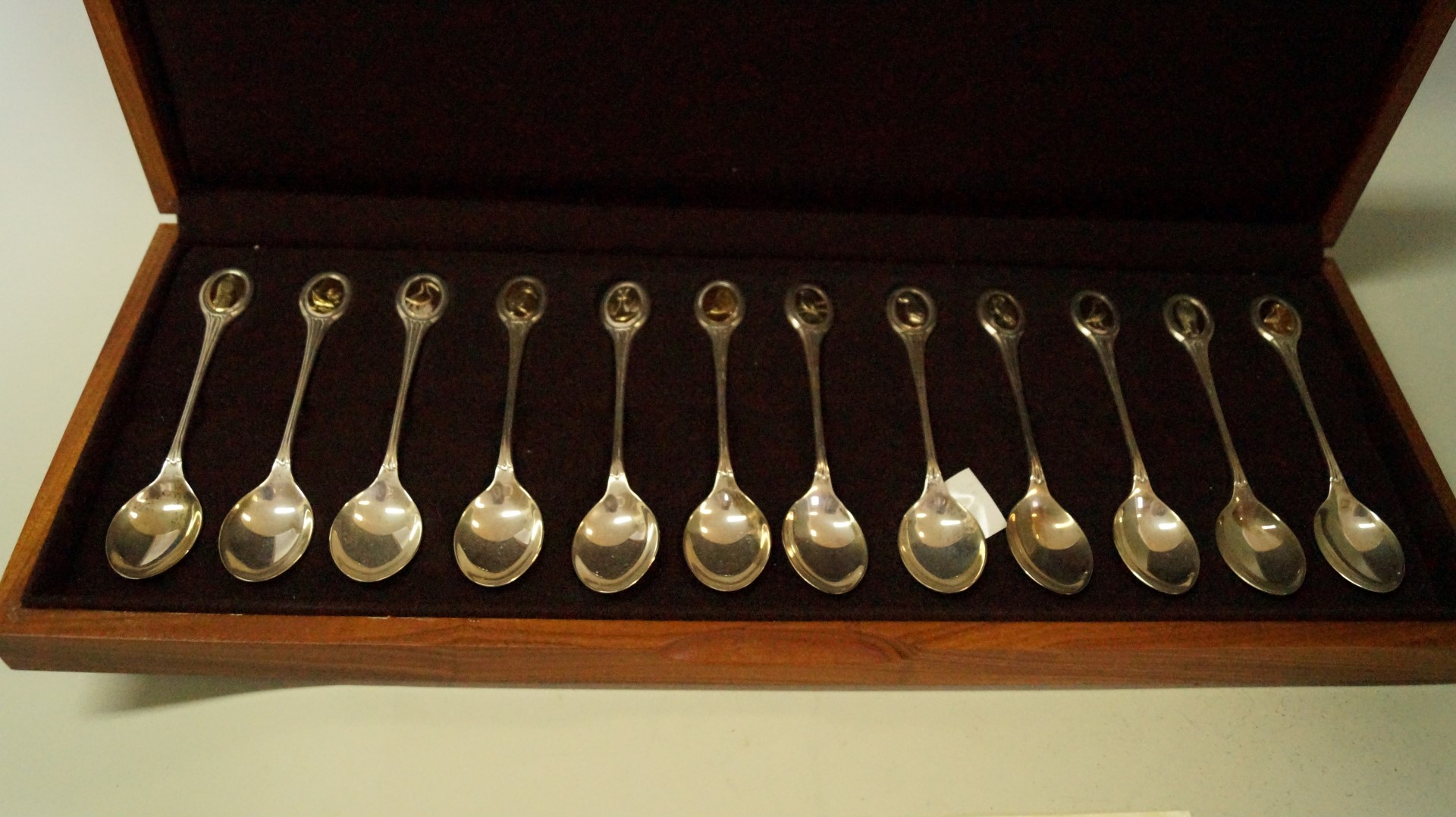 A cased set of twelve RSPB silver gilt teaspoons, by John Pinches, London 1975, 330g,