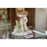 A Meissen figure of a child gardening, 12cm high, (chips to leaves).