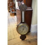 An early 20th century carved oak aneroid barometer.