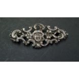 A Victorian silver bar brooch decorated cherub face surrounded by C scrolls, by C.F, London 1901, 5.