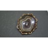 A large agate brooch in ornate metal mount.