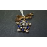 An unmarked Victorian white and yellow metal pendant set diamonds in a floral setting with blue