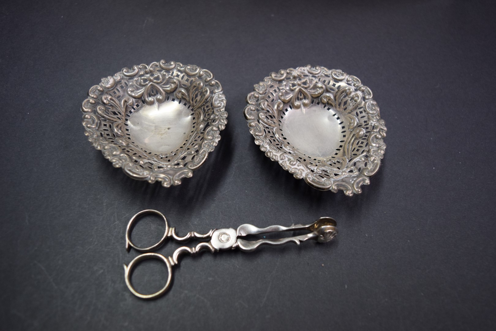 A pair of reticulated silver bonbon bowls; together with a pair of George III silver sugar tongs, - Image 3 of 3