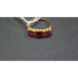 An 18ct gold ring set three rubies and diamond chips.