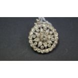 An unmarked yellow metal diamond set circular floral brooch/pendant, 2.