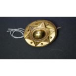 A Victorian unmarked yellow metal Etruscan style oval brooch,