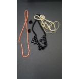 A French jet necklace; together with a coral bead necklace; two single strand pearl necklaces;