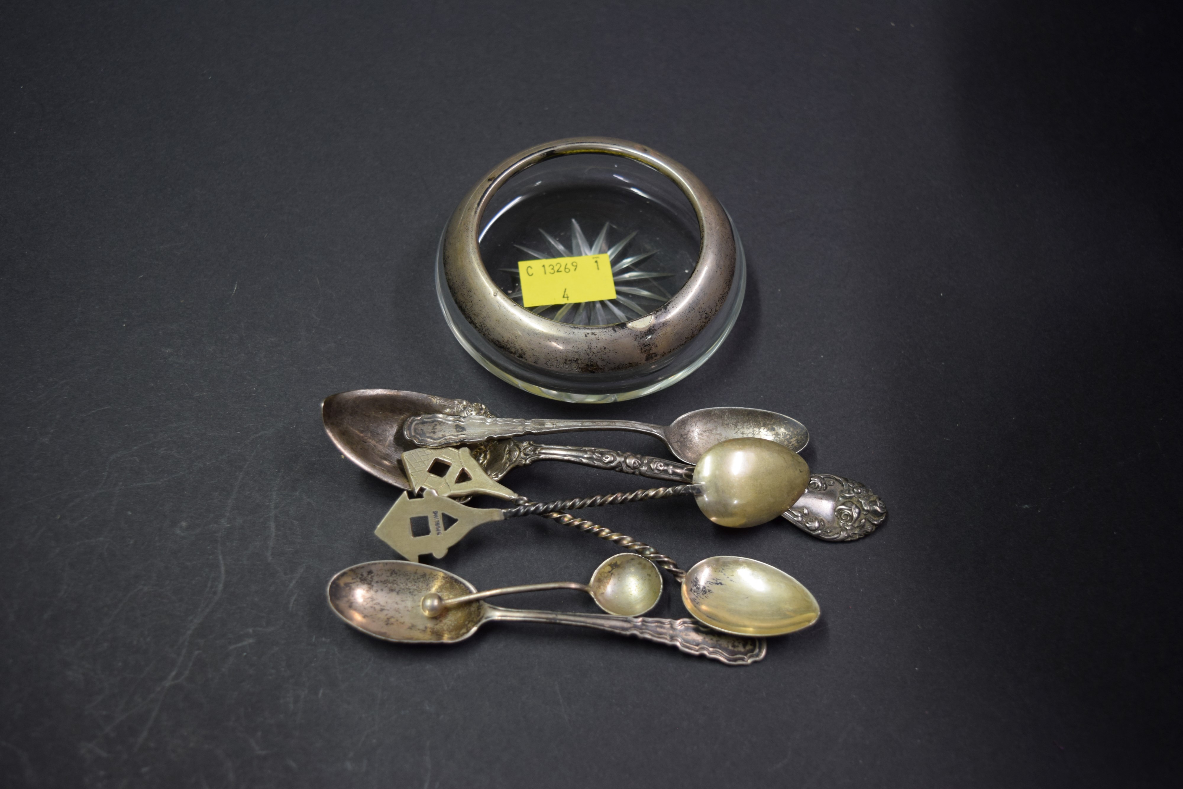 A German .835 mounted glass ashtray and six various silver spoons.