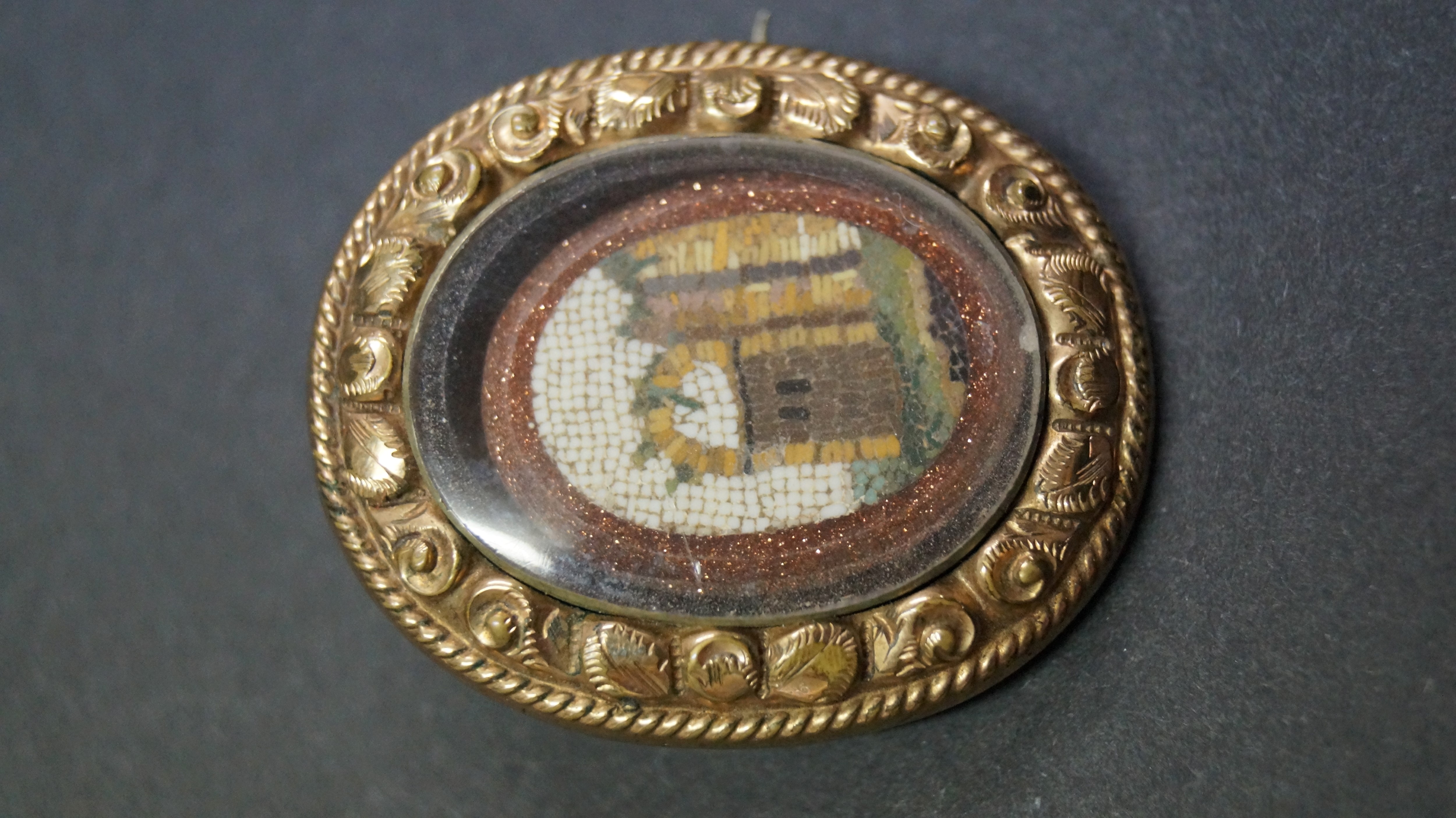 An antique micro mosaic brooch depicting ruin, in gold coloured frame, 3.5 x 3cm.