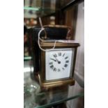 An old brass carriage timepiece, height including handle 13cm,