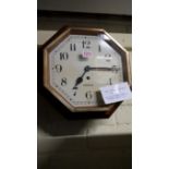 A 1930s faux grained octagonal wall clock, the painted dial inscribed Garrard, 31cm wide,