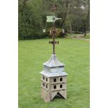 A wrought iron and copper weathervane circa 1880 on later wooden dovecote base 287cm.; 113ins high