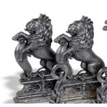 A pair of cast iron doorstops mid 19th century in the form of seated lions with armorial shields