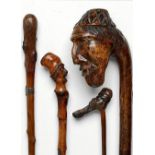 Walking Sticks: A wood cane carved with a rustic's head with inlaid glass eyes