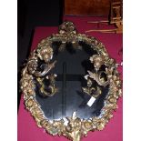 A metal French style mirror with attached candleholders