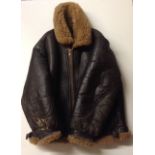 A BROWN LEATHER AND SHEEPSKIN FLYING JACKET Having a zip front, large collar, neck and waist