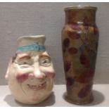 A ROYAL DOULTON TALL BALUSTER VASE With leaf decoration, and a Sarreguemines character jug, the