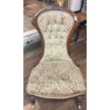 A VICTORIAN WALNUT NURSING CHAIR In floral fabric upholstery.