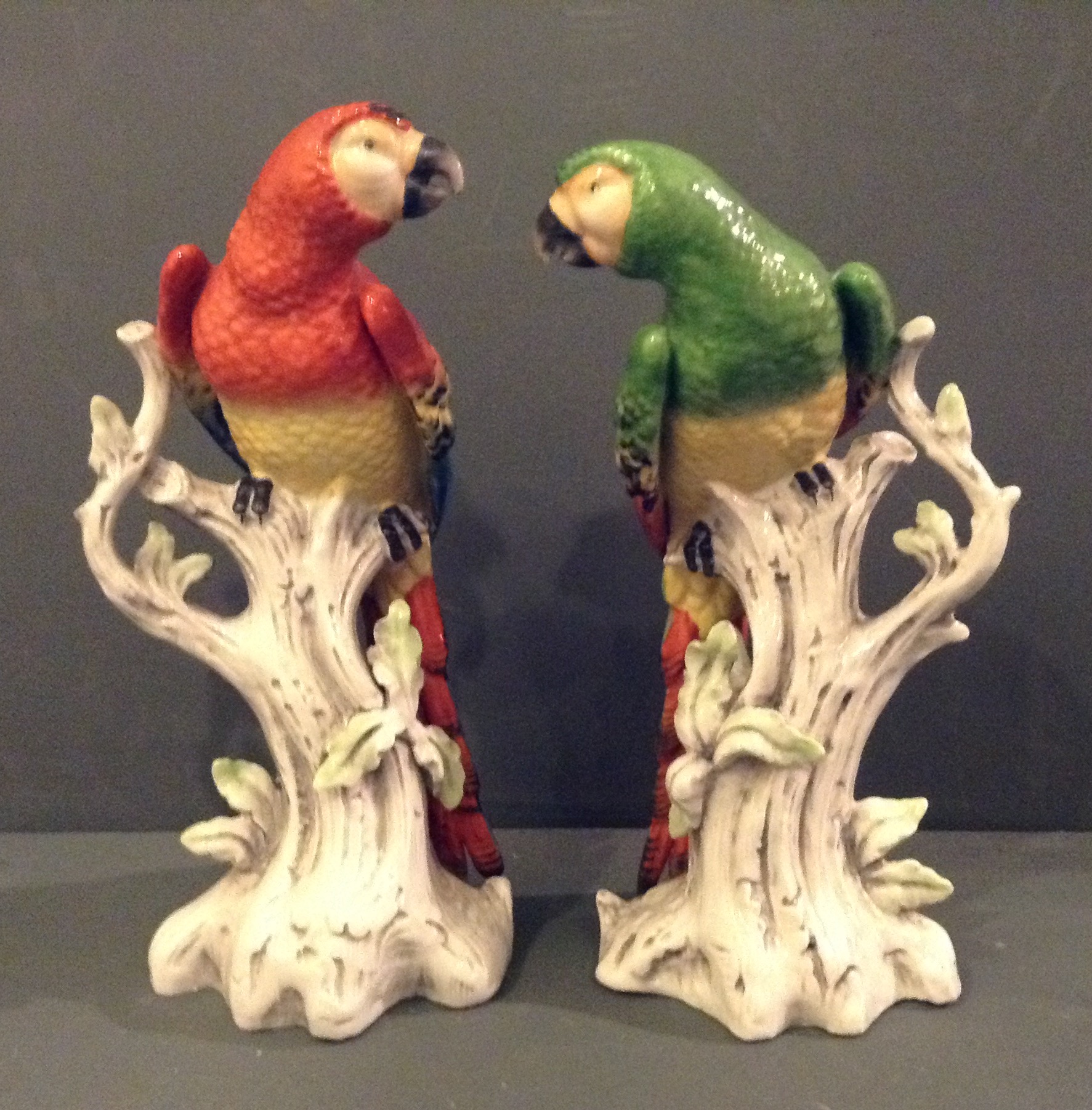 A PAIR OF 19TH CENTURY CONTINENTAL PORCELAIN FIGURES Modelled as parrots perched on a gnarled