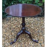 A GEORGIAN MAHOGANY PIECRUST SUPPER TABLE Raised on a turned support and triform legs, with ball and