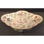 AN 18TH CENTURY CHINESE FAMILLE VERTE DISH Of squat form and lobed shape, the bowl hand painted with