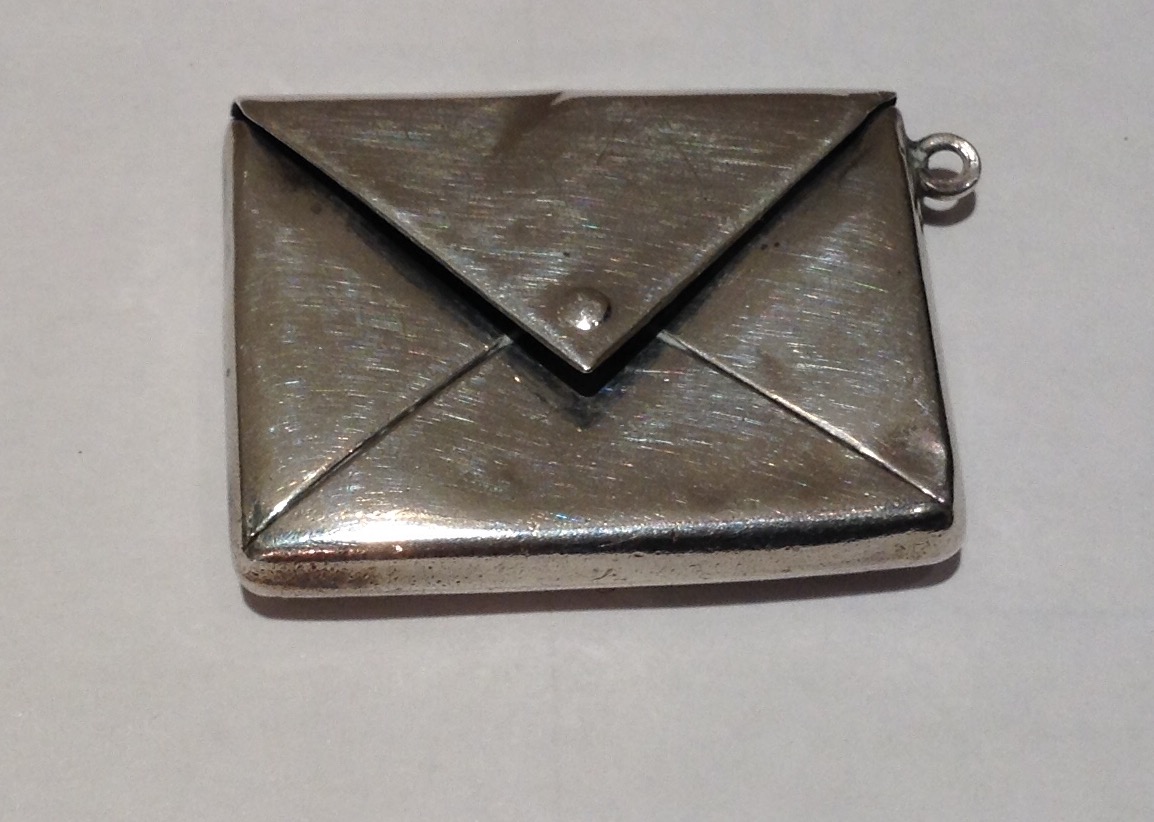 AN EDWARDIAN HALLMARKED SILVER STAMP HOLDER Modelled as an envelope with a folding triangular