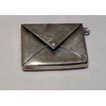 AN EDWARDIAN HALLMARKED SILVER STAMP HOLDER Modelled as an envelope with a folding triangular