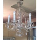 A DECORATIVE GLASS FIVE BRANCH CHANDELIER Hung with prism drops. (drop 64cm)