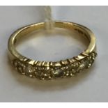 A HALLMARKED 18CT GOLD AND DIAMOND HALF HOOP RING The three principal circular cut diamonds claw