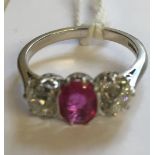 AN EARLY 20TH CENTURY HALLMARKED PLATINUM, RUBY AND DIAMOND THREE STONE DRESS RING The oval cut ruby