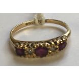 A VICTORIAN STYLE HALLMARKED 9CT GOLD AND RUBY THREE STONE RING The three graduated round cut rubies