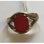 A HALLMARKED 9CT GOLD AND CORNELIAN SIGNET RING The oval Cornelian bezel claw set, to an open backed