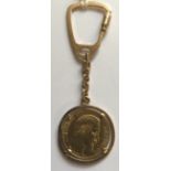 AN 18CT GOLD KEYRING Having an 1858 Napoleon III French surround and suspended from a short cable
