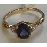 A HALLMARKED 9CT GOLD, TANZANITE AND DIAMOND DRESS RING The oval cut tanzanite claw set to pierced