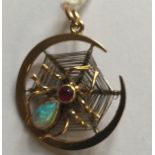 A VINTAGE 9CT GOLD AND GEM SET SPIDER PENDANT The pendant is a crescent, with a spiders web to