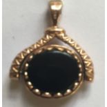 A 9CT GOLD AND HARDSTONE SPINNING TWO SIDED FOB PENDANT With bloodstone on one side and onyx on the