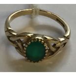 A HALLMARKED 9CT GOLD AND EMERALD DRESS RING The oval cut emerald collet and claw set, to