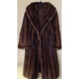 A MINK FUR COAT Having a wide collar and brown fabric lining. (approx l 104cm)
