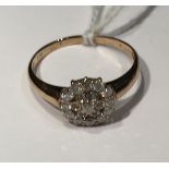 A 9CT GOLD AND DIAMOND CLUSTER/DRESS RING The central daisy cluster of round cut diamonds, to a