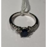 AN 18CT WHITE GOLD, SAPPHIRE AND DIAMOND RING The oval brilliant cut sapphire, set between