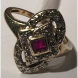 AN ART DECO STYLE 9CT GOLD, RUBY AND DIAMOND DRESS RING The flat pointed oval bezel outlined in