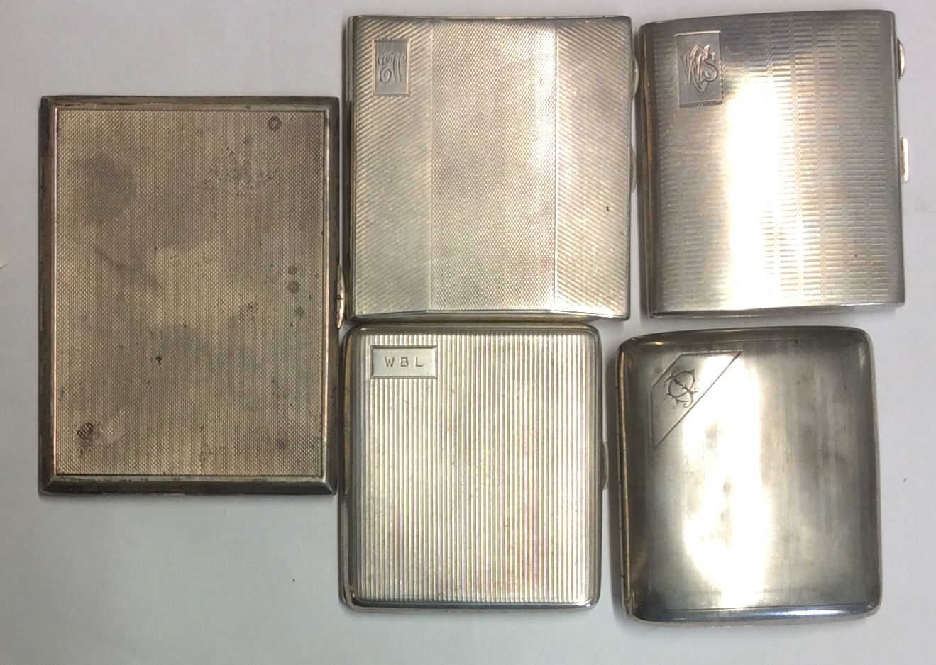 A COLLECTION OF FIVE HALLMARKED SILVER CIGARETTE CASES Having engine turned decoration, including