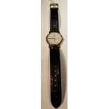 TISSOT, A GENTLEMEN'S 18CT GOLD WATCH With seconds hand, date window and bar markers, on a black