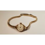 GARRARD, A 9CT GOLD CASED LADIES' WRISTWATCH On an integral 9ct gold strap. 5623/BG1310644/1